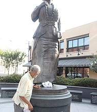 Happy Birthday, Mrs. Walker! Richmond area residents took time recently to remember pioneering Richmond businesswoman Maggie L. Walker in honor of what would have been her 157th birthday on July 15. While she is best known as the first Black woman to found and serve as president of a bank in the United States, she also was a civil rights and voting rights advocate, newspaper publisher, store owner and politician and all around community leader. Melvin Jones Jr., a graduate of the former Maggie L. Walker High School and president of the Maggie L. Walker Statue Foundation, places flowers July 15 at her statue in Downtown at Adams and Broad streets. The statue serves as a gateway to Jackson Ward where Mrs. Walker lived and did much of her work.