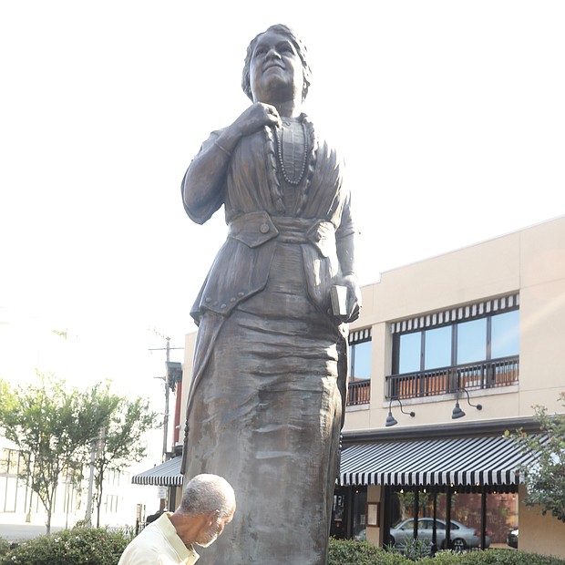 Happy Birthday, Mrs. Walker! Richmond area residents took time recently to remember pioneering Richmond businesswoman Maggie L. Walker in honor of what would have been her 157th birthday on July 15. While she is best known as the first Black woman to found and serve as president of a bank in the United States, she also was a civil rights and voting rights advocate, newspaper publisher, store owner and politician and all around community leader. Melvin Jones Jr., a graduate of the former Maggie L. Walker High School and president of the Maggie L. Walker Statue Foundation, places flowers July 15 at her statue in Downtown at Adams and Broad streets. The statue serves as a gateway to Jackson Ward where Mrs. Walker lived and did much of her work.