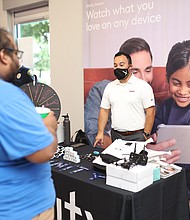 Customer playing the prize wheel at the grand opening of the new XFINITY store on Wallisville Rd.