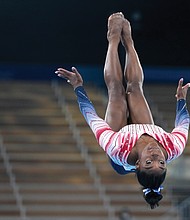 Simone Biles does one of her signature moves on the balance beam Tuesday during the gymnastics competition at Ariake Gymnastics Centre at the Summer Olympics in Tokyo.