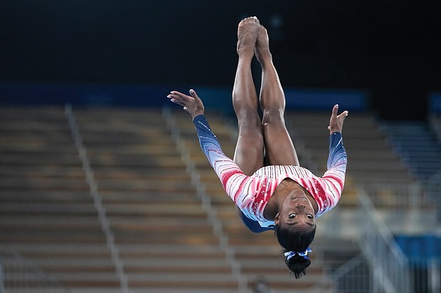 Simone Biles does one of her signature moves on the balance beam Tuesday during the gymnastics competition at Ariake Gymnastics Centre at the Summer Olympics in Tokyo.