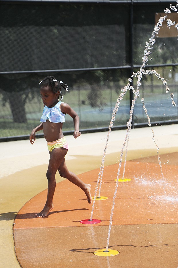 A real splash/Marlei Wyatt-Bey, 5, gingerly enjoys the splash pad Wednesday at Battery Park Pool on Dupont Circle in North Side. The youngster was visiting the pool with her camp group on a day when temperatures reached the 80s in Richmond.