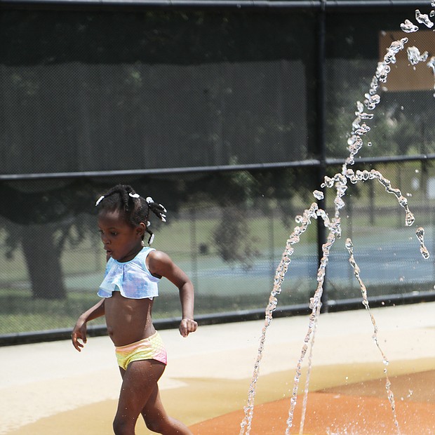 A real splash/Marlei Wyatt-Bey, 5, gingerly enjoys the splash pad Wednesday at Battery Park Pool on Dupont Circle in North Side. The youngster was visiting the pool with her camp group on a day when temperatures reached the 80s in Richmond.