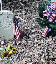 Honoring a Buffalo Soldier/Descendants of Moses Bradford Jr. of Henrico County, a Buffalo Soldier who served in the 25th Infantry during the Spanish-American War, place a wreath on his grave during a twilight memorial service at the Sons and Daughters of Ham Cemetery near Bandy Field in Henrico County on July 28. The family members, from left, Diane Winston Jones, Linda Truman Nash and Spencer Truman, participated in the local commemoration on National Buffalo Soldiers Day, which honors the contributions of some of the earliest African-American troops in the U.S. military. The commemoration included a three-volley salute by members of the Veterans of Foreign Wars Post 9808 in Mechanicsville, and a flag presentation, below, by Najiek Harris, 15, left, and Christian Hicks, 13, of Scout Troop 432 in Church Hill. Pvt. Bradford, who fought during the Battle of El Caney in Cuba on July 1, 1898, suffered a heat stroke while in Cuba and was returned home as a casualty of war. He was honorably discharged from the military in 1899, and went on to live to the age of 55, succumbing in 1925. His government-issued gravestone is one of only two left in the historic African-American cemetery that is located on an acre of land purchased by the Ham Council in 1873 and now is listed with the Virginia Department of Historic Resources.