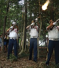 Honoring a Buffalo Soldier/Descendants of Moses Bradford Jr. of Henrico County, a Buffalo Soldier who served in the 25th Infantry during the Spanish-American War, place a wreath on his grave during a twilight memorial service at the Sons and Daughters of Ham Cemetery near Bandy Field in Henrico County on July 28. The family members, from left, Diane Winston Jones, Linda Truman Nash and Spencer Truman, participated in the local commemoration on National Buffalo Soldiers Day, which honors the contributions of some of the earliest African-American troops in the U.S. military. The commemoration included a three-volley salute by members of the Veterans of Foreign Wars Post 9808 in Mechanicsville, and a flag presentation, below, by Najiek Harris, 15, left, and Christian Hicks, 13, of Scout Troop 432 in Church Hill. Pvt. Bradford, who fought during the Battle of El Caney in Cuba on July 1, 1898, suffered a heat stroke while in Cuba and was returned home as a casualty of war. He was honorably discharged from the military in 1899, and went on to live to the age of 55, succumbing in 1925. His government-issued gravestone is one of only two left in the historic African-American cemetery that is located on an acre of land purchased by the Ham Council in 1873 and now is listed with the Virginia Department of Historic Resources.