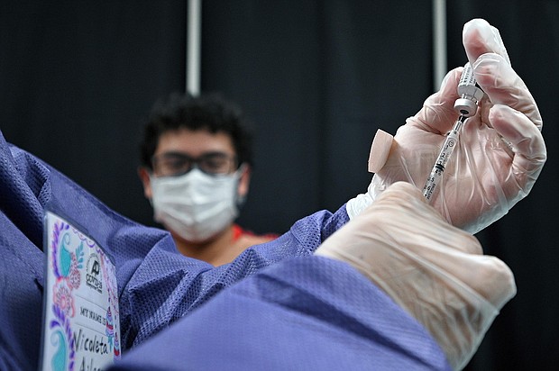 A patient looks on as a registered nurse prepares a syringe with a dose of Pfizer COVID-19 vaccine at a vaccination site in the Queens borough of New York, NY, July 30, 2021.
Mandatory Credit:	ANTHONY BEHAR/SIPA USA/AP