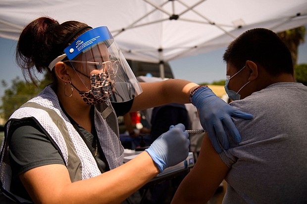 A 12-year-old receives a first dose of the Pfizer Covid-19 vaccine at a mobile vaccination clinic during a back to school event in Los Angeles.
Mandatory Credit:	Patrick T. Fallon/AFP/Getty Images