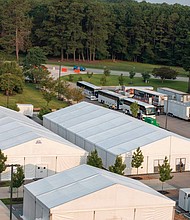 Buses transporting Afghan special immigrant applicants from Dulles International Airport arrive at Fort Lee outside of Petersburg on July 30. The military post is providing temporary housing, health screenings and initial services to what is expected to be about 3,500 Afghan evacuees who are being relocated to the United States. They helped U.S. troops during the war in Afghanistan and their lives, and those of their families, would be in danger by the Taliban if they remain.