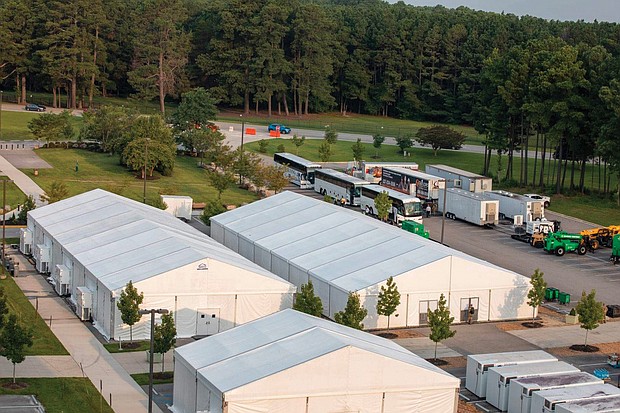 Buses transporting Afghan special immigrant applicants from Dulles International Airport arrive at Fort Lee outside of Petersburg on July 30. The military post is providing temporary housing, health screenings and initial services to what is expected to be about 3,500 Afghan evacuees who are being relocated to the United States. They helped U.S. troops during the war in Afghanistan and their lives, and those of their families, would be in danger by the Taliban if they remain.