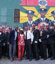 Scores of people turned out Aug. 6 for the official unveiling of the mural honoring the first Black firefighters hired by the City of Richmond. The 10 trailblazers were hired July 1, 1950, and were stationed at Engine Company No. 9 at 5th and Duval streets in Jackson Ward. The commemorative mural was done by local artists Sir James Thornhill, Jason Ford and Kevin Orlosky, and is situated on the side of the Mocha Temple No. 7 Shrine building at 613 N. 2nd St. in Jackson Ward. Members of Mocha Temple pose for a group photo with, at center, Mayor Levar M. Stoney; Mr. Thornhill; and Fire Chief Melvin D. Carter. The unveiling was the kickoff of a weekend of activities sponsored by Engine Company #9 and Associates remembering and honoring the original firefighters.