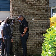 Police Chief Gerald Smith consoles the mother of one of the victims injured in gun violence April 27 at the Belt Atlantic Apartments in South Side. Sharnez Hill, 30, and her 3-month-old daughter were killed in the shooting and three others, ages 29, 15 and 11, were wounded. Chief Smith marched with scores of people attending a rally sponsored by Men in Action on May 1 calling for an end to the violence. The group marched from George Wythe High School to the apartment complex, where Chief Smith tried to comfort the mother.