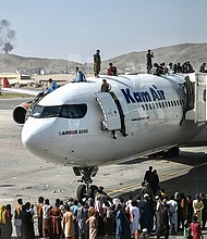 Afghan people climb atop a plane attempt to leave Kabul on Aug. 16. The US has come under scrutiny over its hasty and chaotic withdrawal, which continued at the airport on Aug. 17.
Mandatory Credit:	Wakil Kohsar/AFP/Getty Images