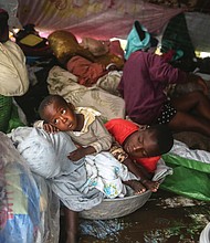 More devastation in Haiti/Earthquake survivors in southern Haiti huddle in a tent Tuesday trying to shield themselves from Tropical Storm Grace’s torrential rains. The storm hit just three days after the desperately poor country suffered major damage and loss of life from its latest devastating earthquake on Saturday morning. Nearly 2,000 people were killed, 9,900 others injured and 37,000 homes destroyed in a section of the Caribbean nation located 80 miles from the capital Port-au-Prince in the magnitude 7.2 quake. (photo: Joseph Odelyn/Associated Press)