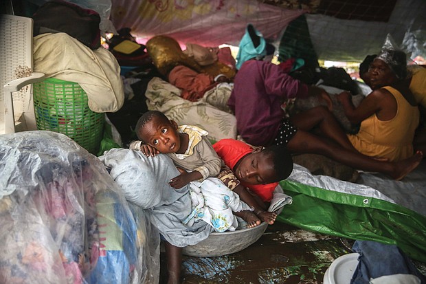 More devastation in Haiti/Earthquake survivors in southern Haiti huddle in a tent Tuesday trying to shield themselves from Tropical Storm Grace’s torrential rains. The storm hit just three days after the desperately poor country suffered major damage and loss of life from its latest devastating earthquake on Saturday morning. Nearly 2,000 people were killed, 9,900 others injured and 37,000 homes destroyed in a section of the Caribbean nation located 80 miles from the capital Port-au-Prince in the magnitude 7.2 quake. (photo: Joseph Odelyn/Associated Press)