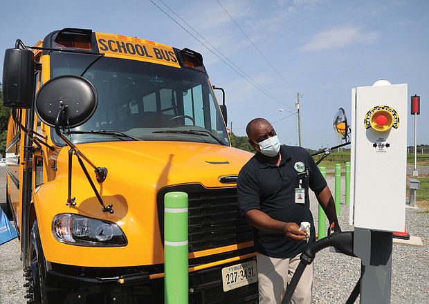 New wheels for Chesterfield schools/Al Parham, supervisor of Chesterfield County Public Schools’ bus fleet, wipes off the plug-in station for the school system’s two new electric school buses during a “Plug-in Ceremony” Aug. 12 at the county’s bus maintenance facility, 7300 Walmsley Blvd. School and county officials, along with officials from Dominion Energy, attended the event held to show off the two new vehicles that were delivered in May. Chesterfield is the first municipality in Metro Richmond to receive the electric school buses through a program sponsored by Dominion Energy. Under the program, school districts pay no more for the electric buses than they would for a diesel model. The program also covers the cost of the charging stations. The first 50 buses were provided under the program in 2020 to 14 school districts in various parts of the state. (photo: Regina H. Boone/Richmond Free Press)