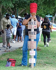 Kimberly Dyke-Harsley displays her own message about freedom as she listens to the speakers at last Saturday’s parole restoration rally at Chimborazo Park.