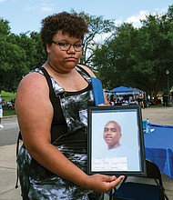 Savannah Watkins, 19, holds a picture of her father, Calvin Watkins, who has been incarcerated since 2004 at Buckingham Correctional Center. She said she doesn’t remember her father outside of prison.