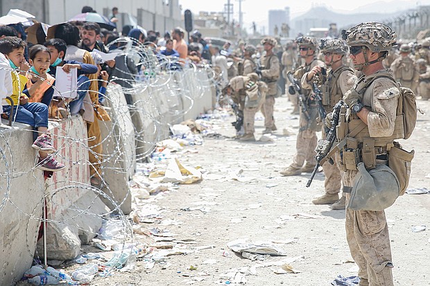 US Marines provide assistance during an evacuation at Hamid Karzai International Airport, Kabul, Afghanistan, on August 20.
Mandatory Credit:	US Marine Corps