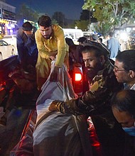 Volunteers and medical staff unload bodies from a pickup truck outside a hospital after two powerful explosions outside the airport in Kabul on August 26.
Mandatory Credit:	Wakil Kohsar/AFP/Getty