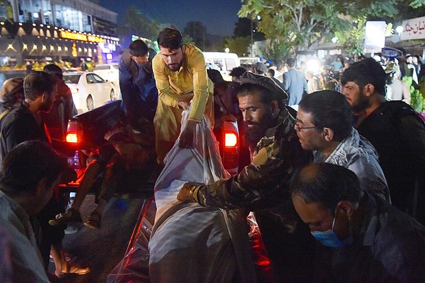Volunteers and medical staff unload bodies from a pickup truck outside a hospital after two powerful explosions outside the airport in Kabul on August 26.
Mandatory Credit:	Wakil Kohsar/AFP/Getty
