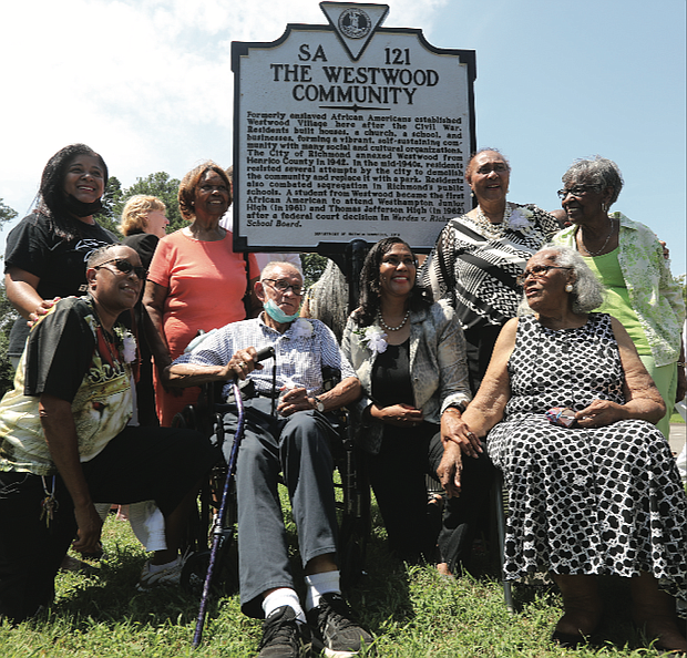 Current and former residents of Westwood celebrate last Sunday a new state historical marker honoring the community in Richmond’s West End that was started by formerly enslaved people following the Civil War. Location of marker: Willow Lawn Drive and Dunbar Street. 
Residents built homes, a church, a school and businesses, as well as social and cultural organizations in the community that originally was a part of Henrico County. It was annexed to Richmond in 1942 and residents later successfully fought attempts by city officials to demolish the community and replace it with a public park. Westwood Baptist Church remains the most prominent landmark. Kathleen Hopkins Valentine, 93, seated at right, is the oldest resident living in Westwood. She said she and her family moved when she was 4 from Philadelphia to what was then called Westwood Village. Others pictured here are, from left, Kelly Johnson Crowder, whose mother, Jane Cooper Johnson, integrated Westhampton Junior High and Thomas Jefferson High School in the early 1960s; Charlene Hopkins, kneeling, and Frances Bush Jones, both cousins of tennis great Arthur Ashe Jr., whose grandparents lived in Westwood; Warrick Taylor, a former Westwood resident; Norfolk State University professor Dr. Colita Nichols Fairfax, immediate past chair of the Virginia Board of Historic Resources, kneeling, and her mother, Brenda Dabney Nichols, who was born and raised in Westwood; and Lennie Anderson Thornton, a former Westwood resident. The Friends of Westwood Playground paid for the marker.