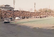 This photo gives evidence of the huge crowds that packed the City Stadium during the heyday of the big contest between the two city high schools. Antique cars parade in front of the stands during pre-game festivities in this scene.