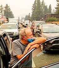 Jim Mrazek stands outside his vehicle on Highway 50 as evacuee traffic stands still in South Lake Tahoe, California on August 30.
Mandatory Credit:	Noah Berger/AP