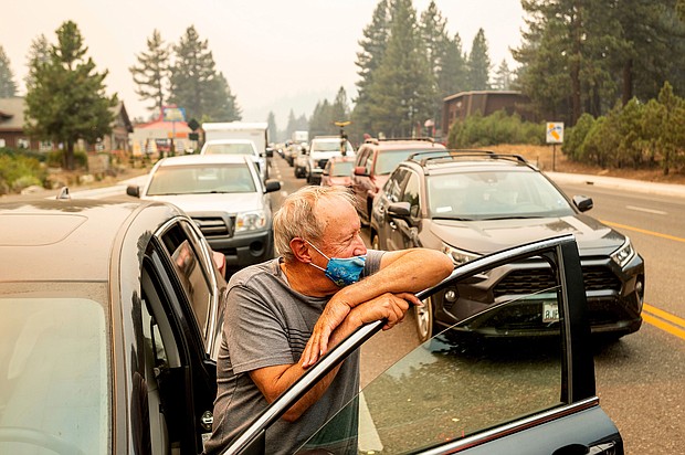 Jim Mrazek stands outside his vehicle on Highway 50 as evacuee traffic stands still in South Lake Tahoe, California on August 30.
Mandatory Credit: Noah Berger/AP