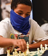 Making a move/Denzel Johnson, 14, a student at CodeRVA Regional High School, makes a bold move during the Bright Minds RVA Chess Tournament last Friday at the Black History Museum and Cultural Center of Virginia. The pilot program drew area youngsters to classes and competition sponsored by the Bernice E. Travers Foundation. (photo by Clement Britt)