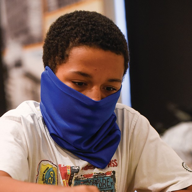 Making a move/Denzel Johnson, 14, a student at CodeRVA Regional High School, makes a bold move during the Bright Minds RVA Chess Tournament last Friday at the Black History Museum and Cultural Center of Virginia. The pilot program drew area youngsters to classes and competition sponsored by the Bernice E. Travers Foundation. (photo by Clement Britt)