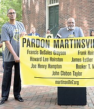 Former Richmond Mayor Rudolph McCollum Jr., center, speaks Tuesday at a rally in Capitol Square that turned into a celebration after Gov. Ralph S. Northam announced he had given posthumous pardons to the Martinsville Seven. Holding the banner are Timothy R. Thomas, left, and Craig Watson. Mr. McCollum’s uncle, Booker T. Millner, and great uncle, Francis DeSales Grayson, were among the seven men executed in 1951.