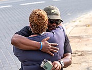 Devon Henry, president and chief executive officer of the Newport News-based Team Henry Enterprises, hugs his mother, Freda Thornton, after the Lee statue came down on Wednesday. Mr. Henry’s company was responsible for the removal and disassembly of the statue for storage in an undisclosed secure location. He faced death threats after his company’s role in removing Richmond’s other Confederate statues in July 2020 was made public.