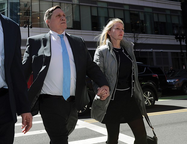 Investor John Wilson, left, arrives at federal court in Boston with his wife, Leslie, to face charges in a nationwide college admissions bribery scandal.