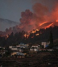 A river of lava flowing from the volcano approaches houses on Spain's La Palma island on Sunday.
Mandatory Credit:	Desiree Martin/AFP/Getty Images