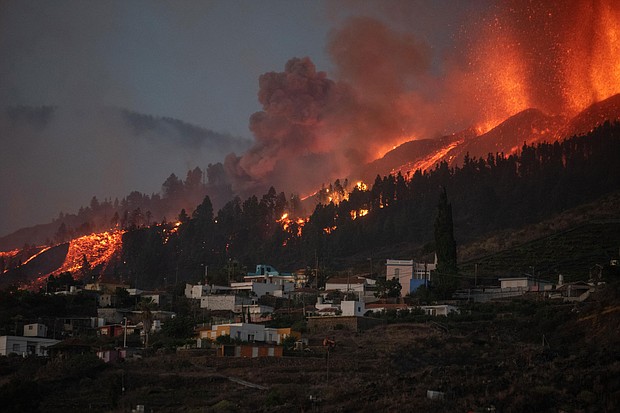 A river of lava flowing from the volcano approaches houses on Spain's La Palma island on Sunday.
Mandatory Credit:	Desiree Martin/AFP/Getty Images