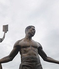 Two new 12-foot bronze statues comprising the Emancipation and Freedom Monument are unveiled and dedicated Wednesday in front of several hundred people at Brown’s Island.