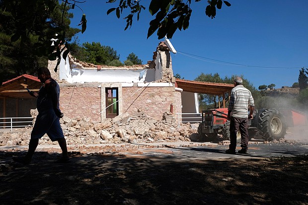 Residents pass next to a damaged Greek Orthodox chapel after a strong earthquake in Arkalochori village on the southern island of Crete, Greece on Monday, September 27.
Mandatory Credit:	Harry Nakos/AP