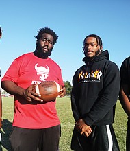 Thomas Jefferson football Coach Josef Harrison, holding football, stands with his senior standouts during Monday’s practice. They are, from left, lineman Lemonta Whitaker, running back Arthur Sutton and lineman Jermaine Booker.