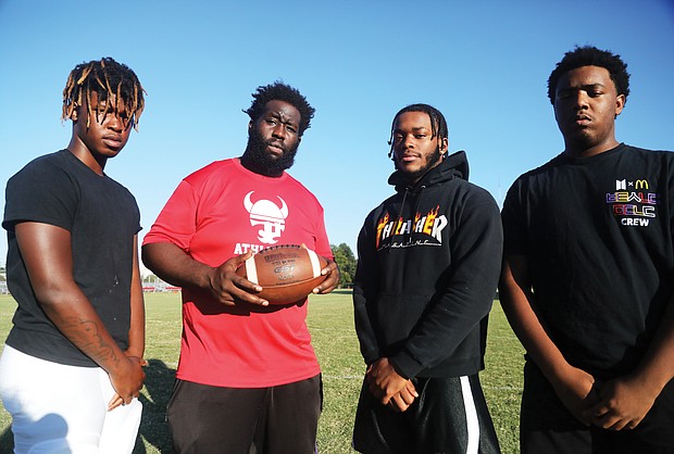 Thomas Jefferson football Coach Josef Harrison, holding football, stands with his senior standouts during Monday’s practice. They are, from left, lineman Lemonta Whitaker, running back Arthur Sutton and lineman Jermaine Booker.