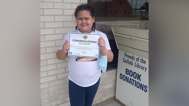 Teresa Sperry holding a certificate from winning the Suffolk Library's reading challenge over the summer.
Mandatory Credit: Courtesy Nicole Sperry
