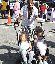 Riding along with Dad-Tre Powell of Richmond grew up attending the annual 2nd Street Festival in Jackson Ward. Last Saturday, he was passing along the tradition to his children, Levi Powell, 4, left, and Olivia Powell, 5, who were enjoying the treats as much as the music.