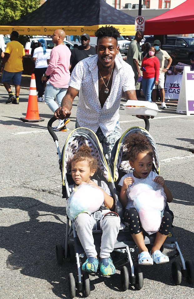Riding along with Dad-Tre Powell of Richmond grew up attending the annual 2nd Street Festival in Jackson Ward. Last Saturday, he was passing along the tradition to his children, Levi Powell, 4, left, and Olivia Powell, 5, who were enjoying the treats as much as the music.