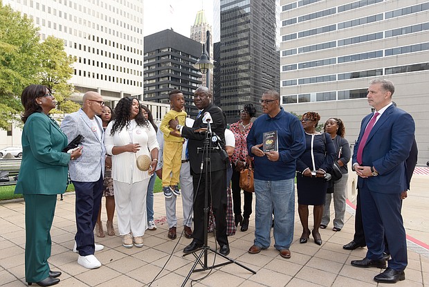 Attorney Ben Crump, center, holds Zayden Joseph, 6, the great-grandson of the late Henrietta Lacks, during a news conference Monday outside of the federal courthouse in Baltimore with Mrs. Lacks’ family members and other attorneys. The Lacks estate is filing suit against a Massachusetts company, Thermo Fisher Scientific, for using Mrs. Lacks’ cells, known as HeLa cells, without the estate’s permission.