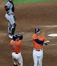 Tucker celebrates with teammate Carlos Correa in Game 2 of the ALDS