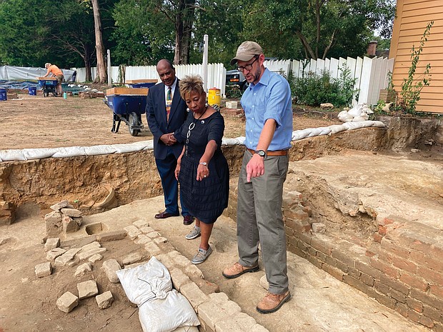 Dr. Reginald F. Davis, left, pastor of First Baptist Church in Williamsburg, Connie Matthews Harshaw, a member of First Baptist, and Jack Gary, Colonial Williamsburg’s director of archaeology, stand Oct 6 at the brick-and-mortar foundation of the old church unearthed in Williamsburg’s historic area.