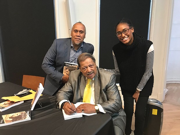 Former Richmond City Councilman Henry W. “Chuck” Richardson signs copies of his new memoir, “Cease Fire! Cease Fire!”, last Saturday for John H. Mitchell, the great-great-nephew of the late Richmond Planet newspaper editor John Mitchell Jr., and Liza Mickens, the great-great-granddaughter of the late noted businesswoman Maggie L. Walker. Location: Black History Museum & Cultural Center of Virginia in Jackson Ward.