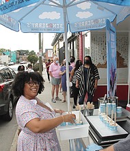 Queen of ice cream Rabia Kamara gives out samples of her winning Ben & Jerry’s ice cream creation “Bia’s Black Joy Sundae” last week to people lined up outside her shop, Ruby Scoops Ice Cream & Sweets, on Brookland Park Boulevard.