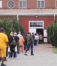 A long line stretches out the door of the Old Dominion building at the Richmond Raceway on tuesday, the first day for the reopened Community Vaccination Center where people can get booster shots or their first or second doses of the COVID-19 vaccine.