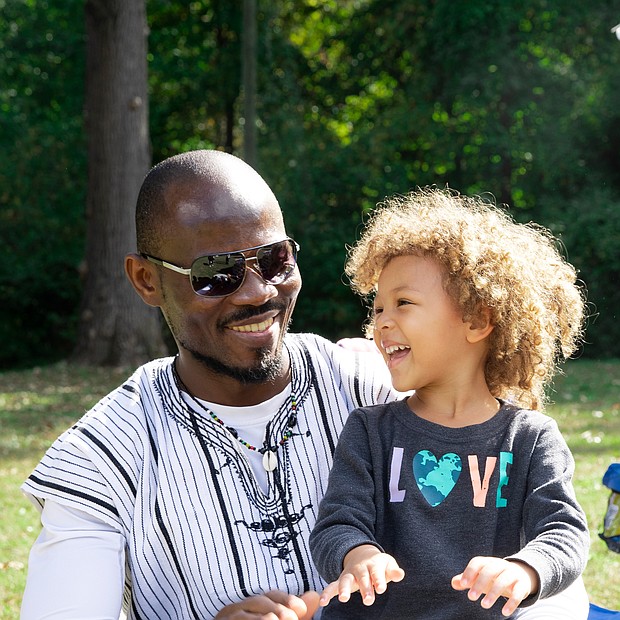 Three-year-old Zara takes a short drumming lesson with her father, Babs, an artist originally from West Africa who now lives in Richmond. Babs, whose paintings include landscapes and African wildlife, was among the bevy of artists participating last Saturday in the 2nd Annual Art Under the Pines exhibition at Pine Camp Cultural Arts & Community Center’s Sculpture Garden. Zara and her older sister, Chali, 9, kept their father company during the event.