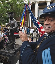 U.S. Colored Troops re-enactor Norman Hill applauds the new statue honoring Black enslaved men who enlisted and served in the Civil War. The statue, by Ohio sculptor Joe Frank Howard, was unveiled Oct. 23 outside the courthouse in Franklin, Tenn.